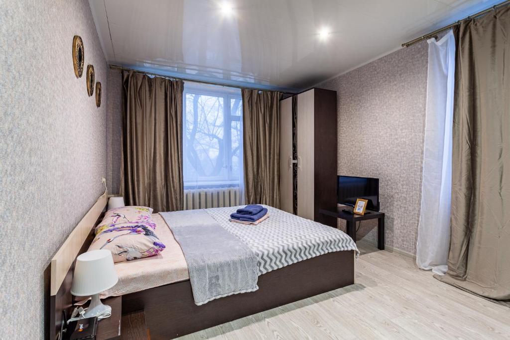 een kleine slaapkamer met een bed en een raam bij Busines Brusnika Apartment Babushkiskaya 1 in Moskou