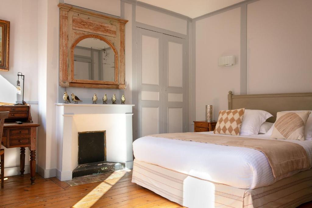 a bedroom with a bed with a fireplace and a mirror at Hotel Le Dauphin in Honfleur