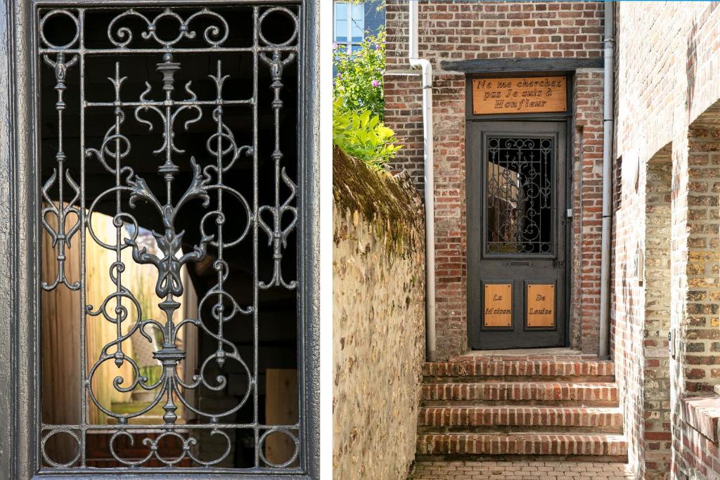a door with a wrought iron gate next to a brick building at Hotel Le Dauphin in Honfleur