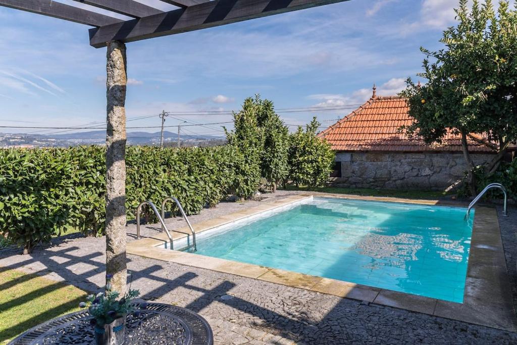 a swimming pool in the backyard of a house at Pequena Casa rústica com piscina in Penafiel