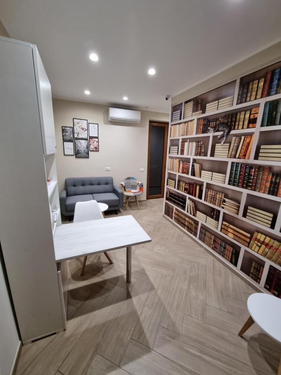 eine Bibliothek mit einem Sofa, einem Tisch und Büchern in der Unterkunft Nonno Umberto Apartments in Pompei