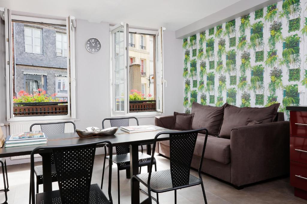 a living room with a couch and a table at Hotel Le Dauphin in Honfleur
