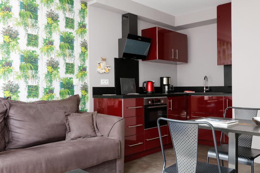 a living room with a couch and a kitchen at Hotel Le Dauphin in Honfleur