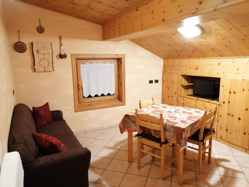 salon ze stołem i kanapą w obiekcie Wood Apartments w Livigno