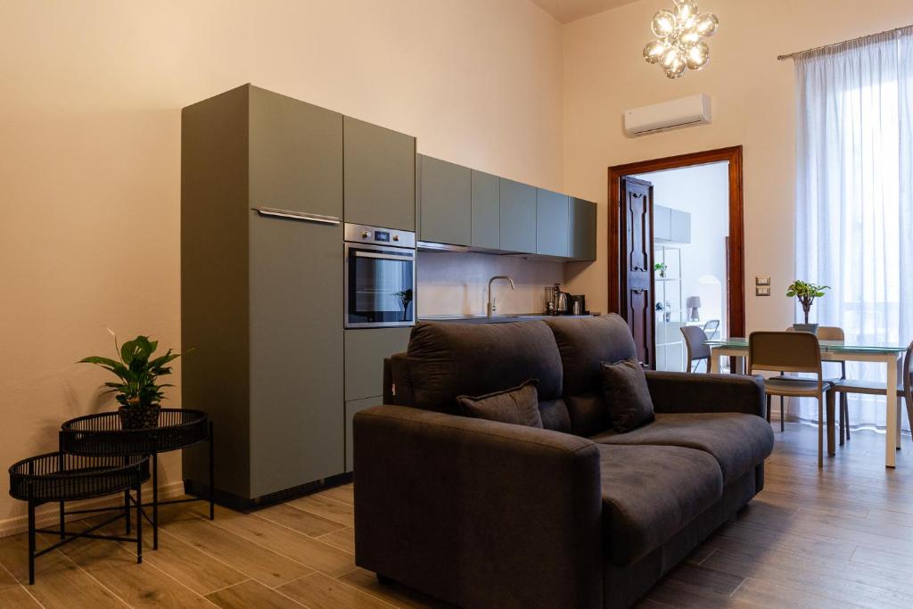 uma sala de estar com um sofá e uma cozinha em La casa di Alice em Parma