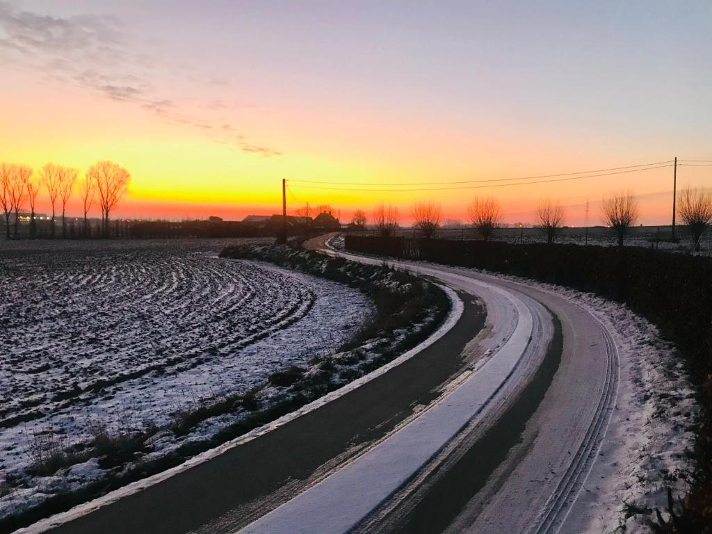 a snow covered road with a sunset in the background at Vakantiewoning in het landelijke Staden! 10 pers - STAEDENBERGH in Staden