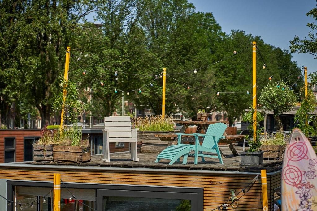 um pátio com cadeiras, mesas e árvores em The Amsterdam Houseboat Family - de Pijp em Amsterdã