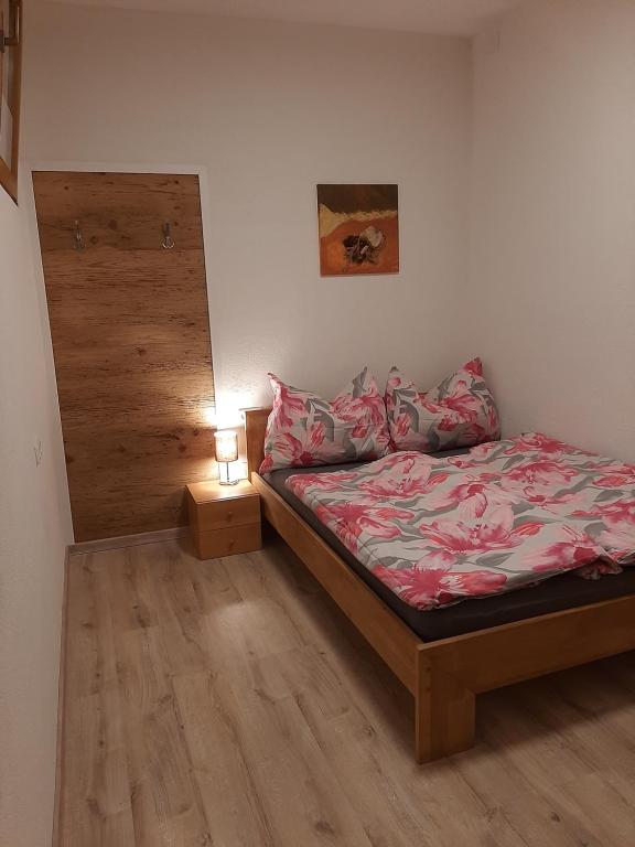 Apart Leonie في هارت إم زيلرتال: غرفة نوم صغيرة مع سرير وموقف ليلي