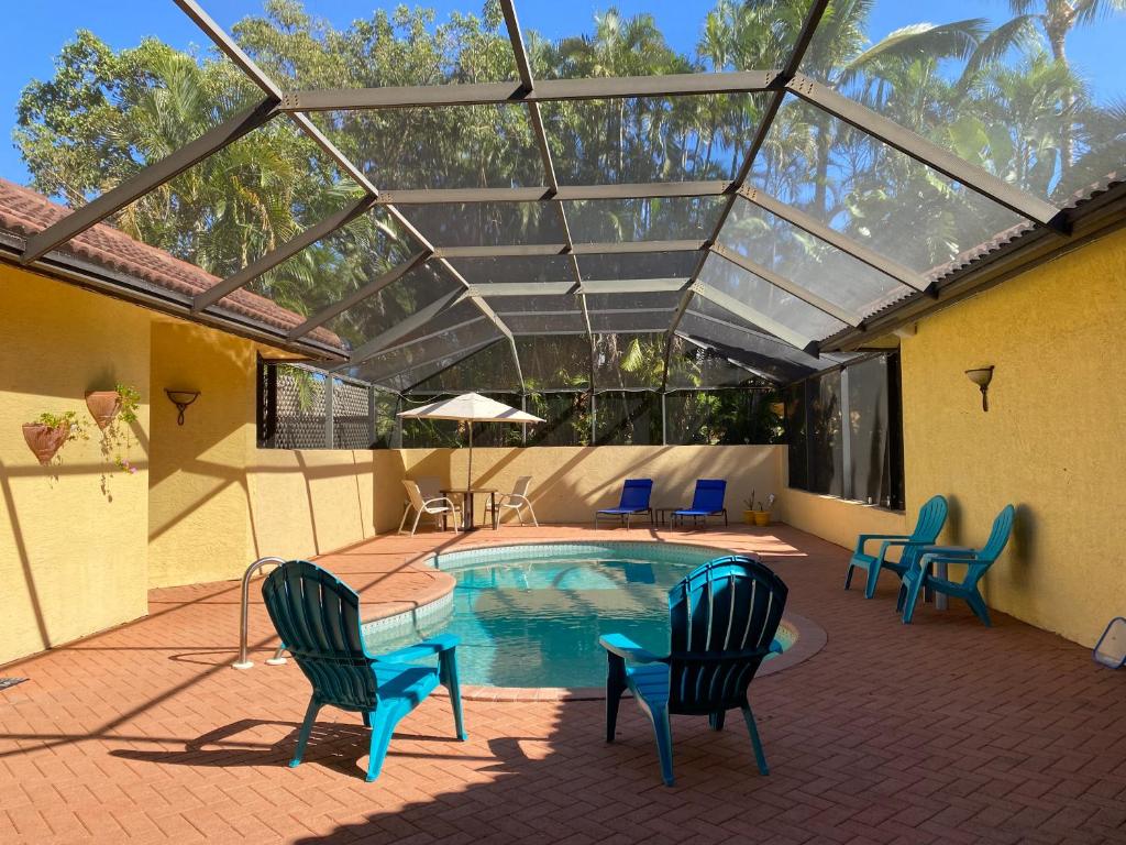 un patio con sillas y una piscina con techo de cristal. en Paradise Found - Private Oasis with Heated Pool on Marco Island en Marco Island