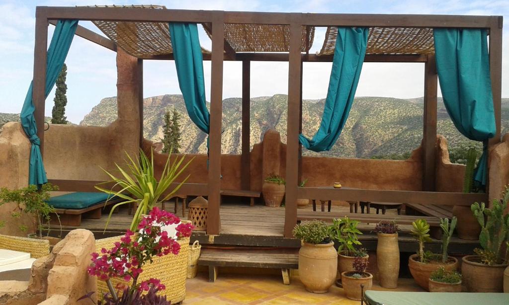 Riad Cascades d'Ouzoud في أوزود: شرفة مع مقعد والنباتات الفخارية