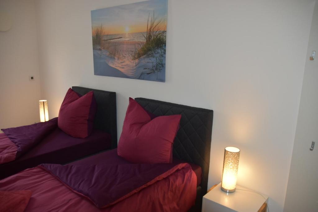 Habitación con 2 camas con almohadas rojas y lámpara. en FeWo-Airport, en Blankenfelde