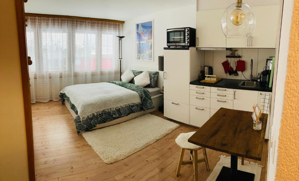 a small bedroom with a bed and a kitchen at Your Pied-à-terre in Davos in Davos