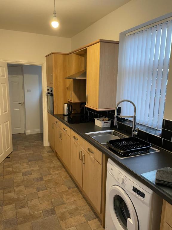 a kitchen with a sink and a washing machine at Bedlington apartment in Bedlington