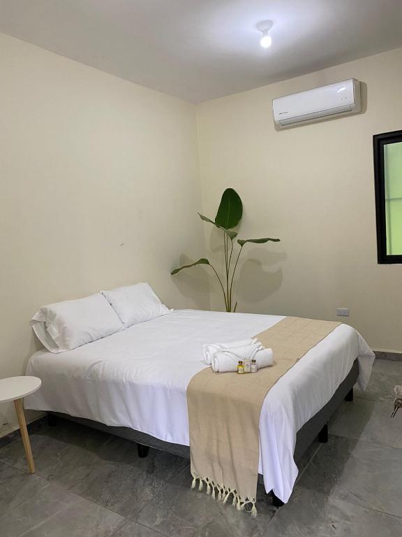 ein Schlafzimmer mit einem weißen Bett, auf dem Handtücher liegen in der Unterkunft Hotel La Isla in Cunduacán