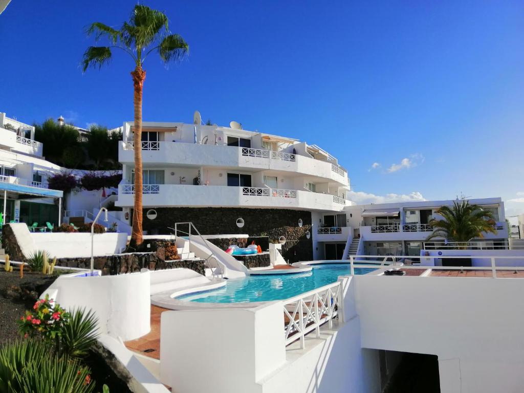 - Vistas a un complejo con piscina y a un edificio en Apartamento Te Miti en Puerto del Carmen