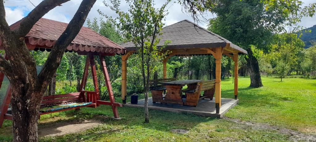 a wooden gazebo with a picnic table in a park at Casa Arabela in Vişeu de Sus