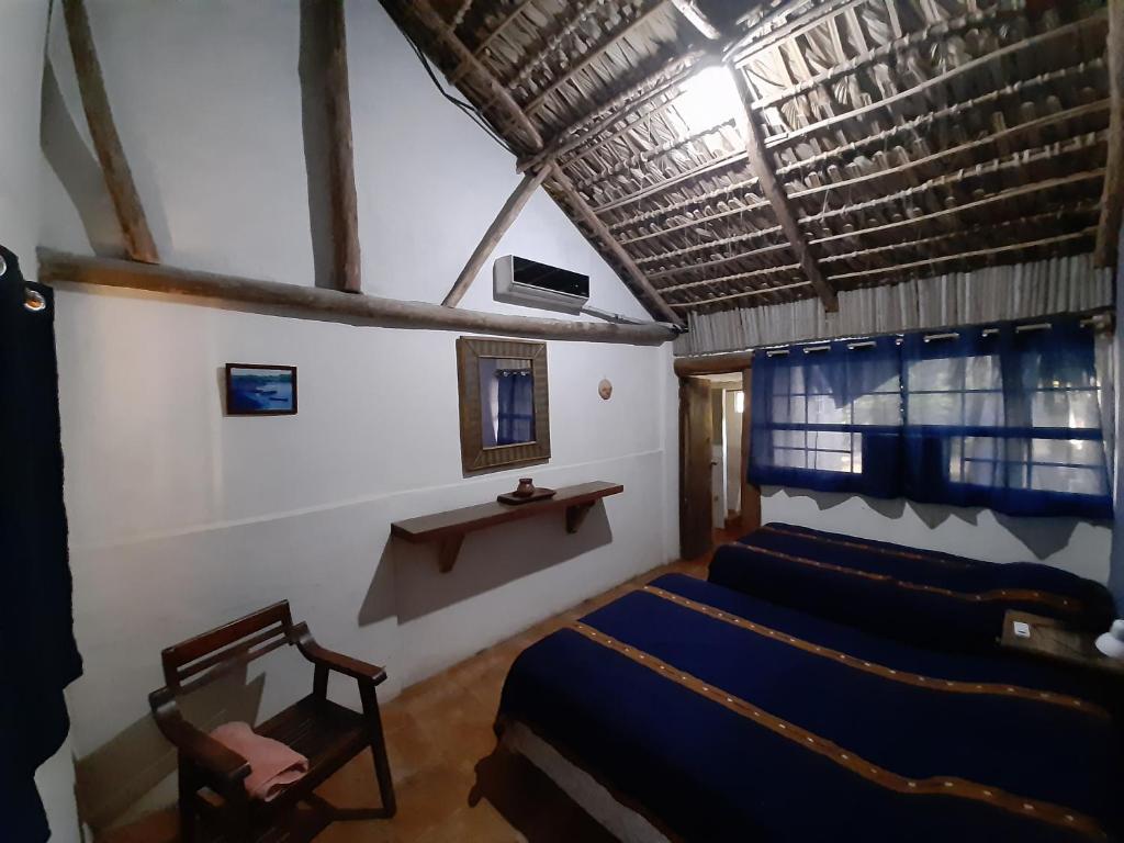 ein Zimmer mit 4 Betten und einem Stuhl darin in der Unterkunft Capricho Beach House in El Zapote