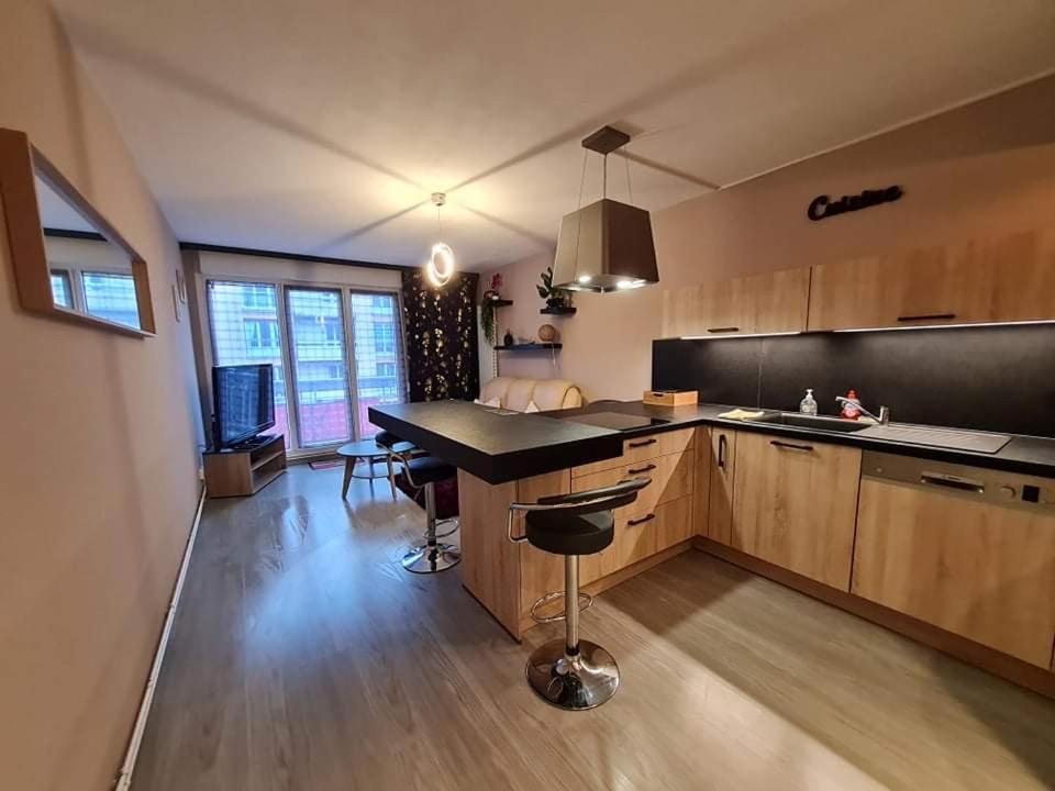 een keuken met een eiland in het midden van een kamer bij Chez Romain, appartement proche commerces et centre ville in Verdun-sur-Meuse
