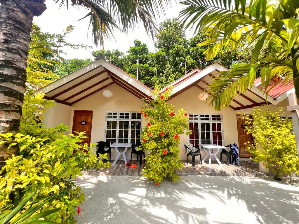 a house with a lot of flowers in front of it at Manta Stay Thoddoo, Maldives in Thoddoo