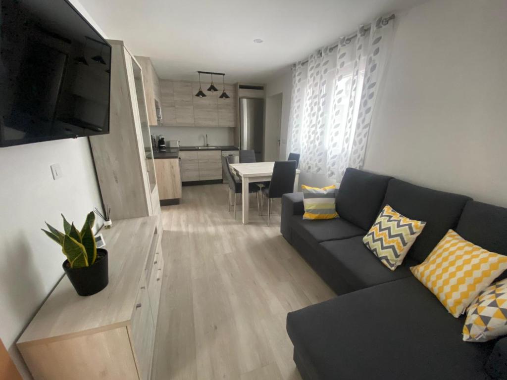 a living room with a couch and a kitchen at Vivienda San José in Teruel