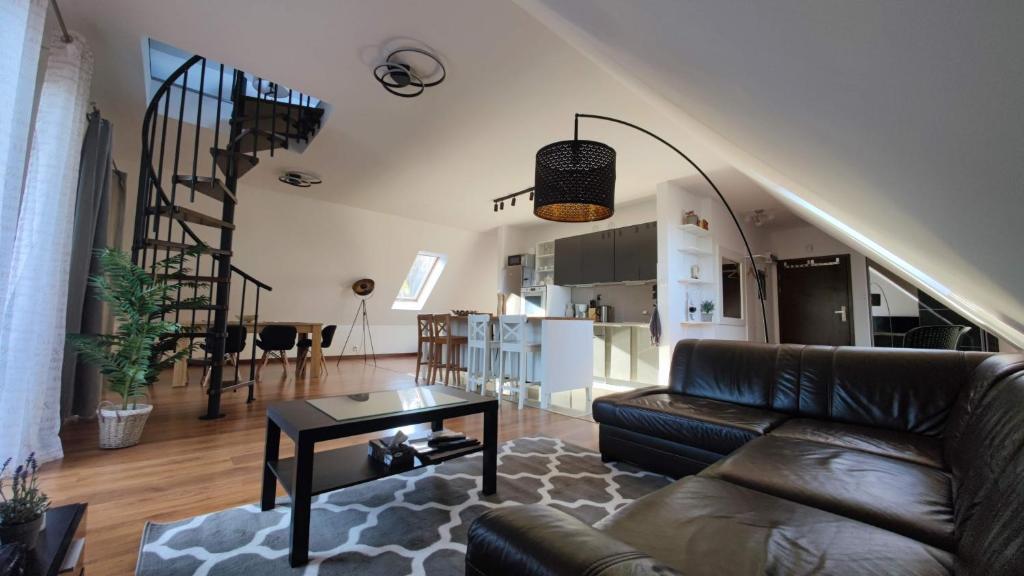 salon ze skórzaną kanapą i stołem w obiekcie Apartament Urocza przy Wyciągu SKI Arena w Szklarskiej Porębie