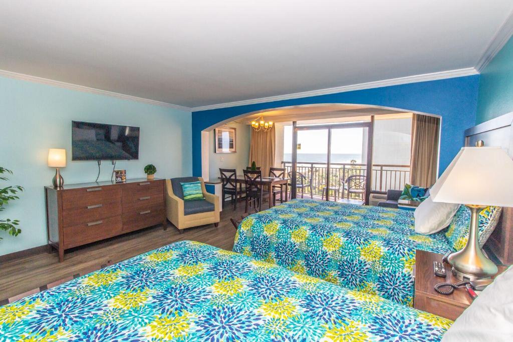 a hotel room with two beds and a balcony at Caravelle 506 in Myrtle Beach