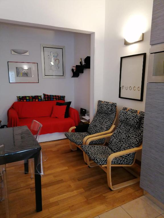a living room with a red couch and chairs at Poggetto home in Florence