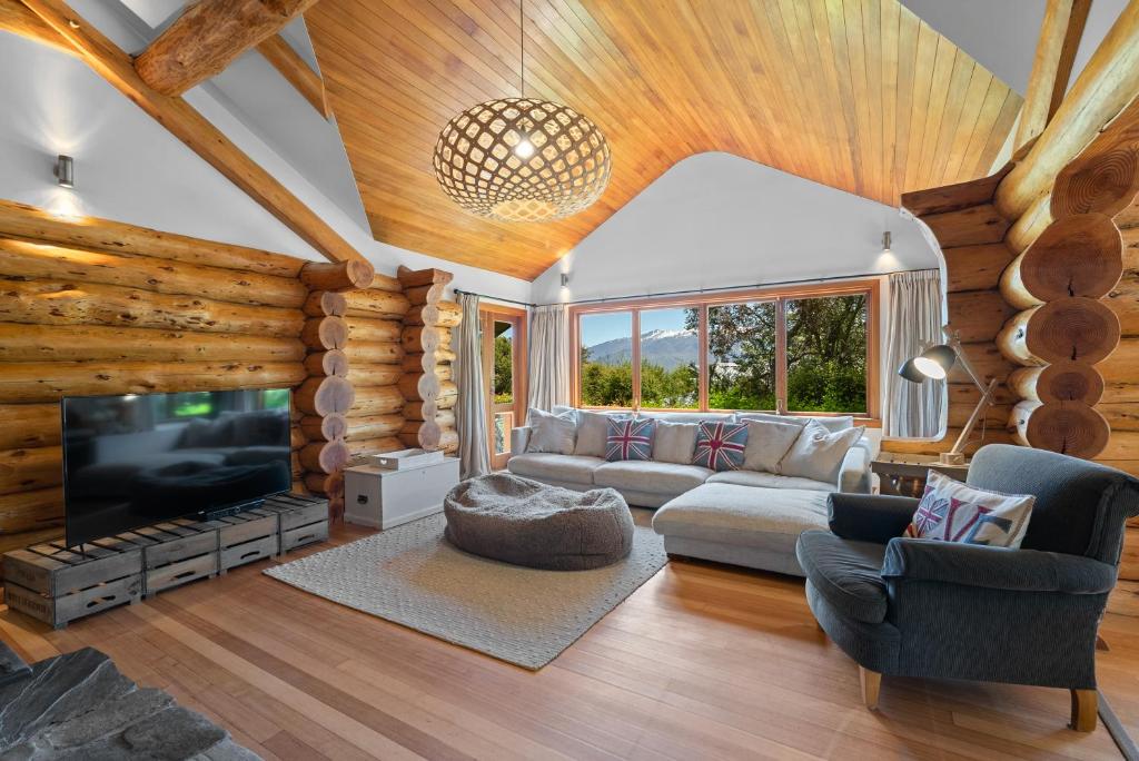 a living room with a couch and a tv at The Log House in Wanaka