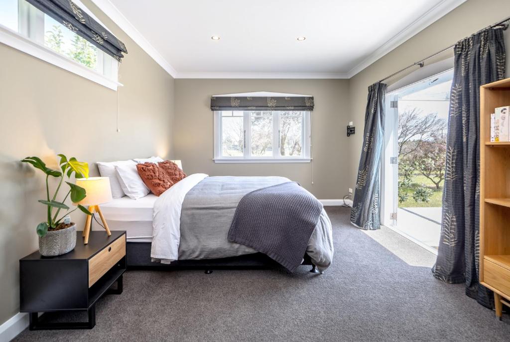 un dormitorio con una cama y una ventana en Brooklands Cottage The Award Winning Villa, en Martinborough