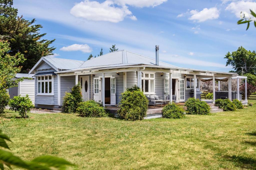 a white house with a large yard at Brooklands Cottage in Martinborough