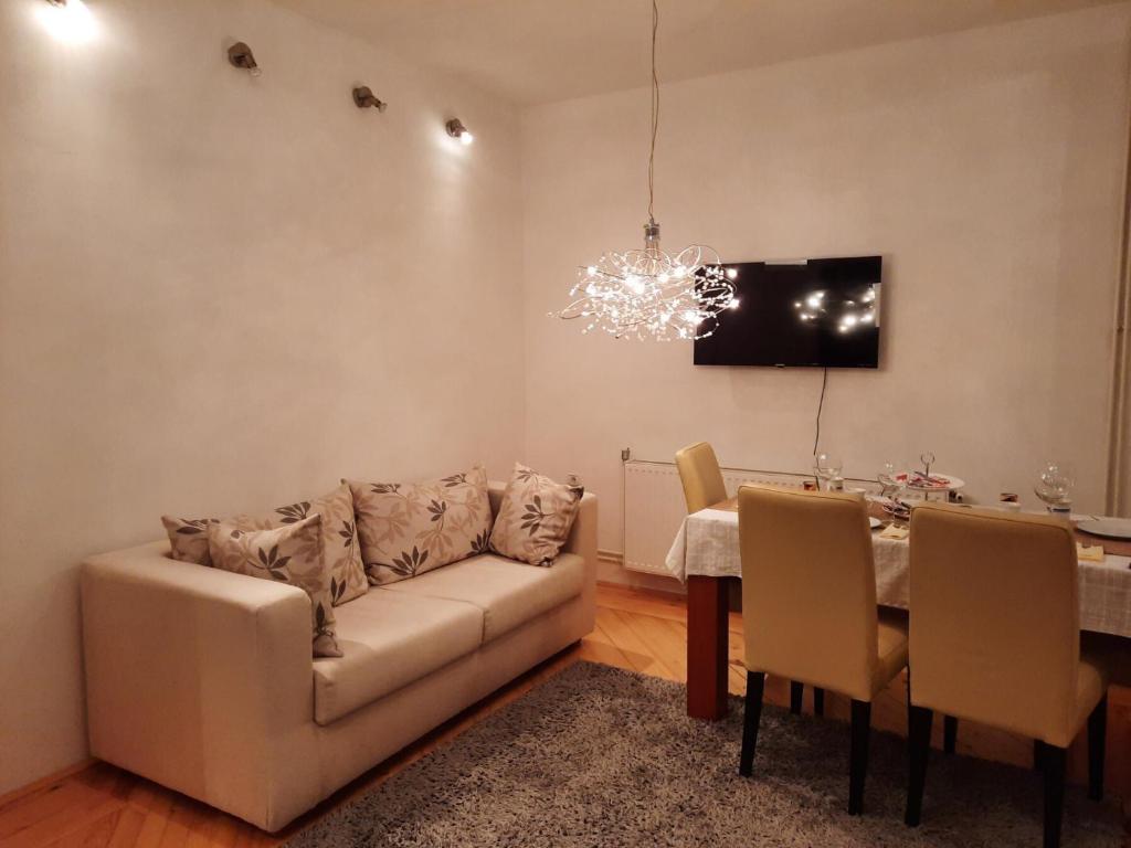 ein Wohnzimmer mit einem Sofa und einem Tisch in der Unterkunft Stan na dan Bijeljina Tijana in Bijeljina