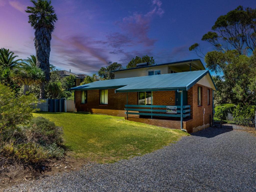 a house with a blue roof on a yard at Breeze on Scenic - 7 Scenic Way, Carrickalinga in Carrickalinga