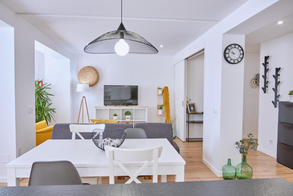 una sala de estar blanca con mesa blanca y sillas en Apartamento San Pedro, en Santiago de Compostela