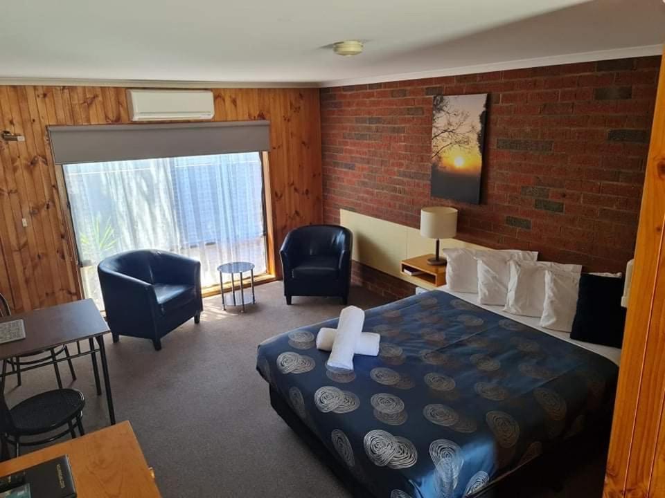 a room with a bed with a cross on it at Kyabram Country Motel in Kyabram