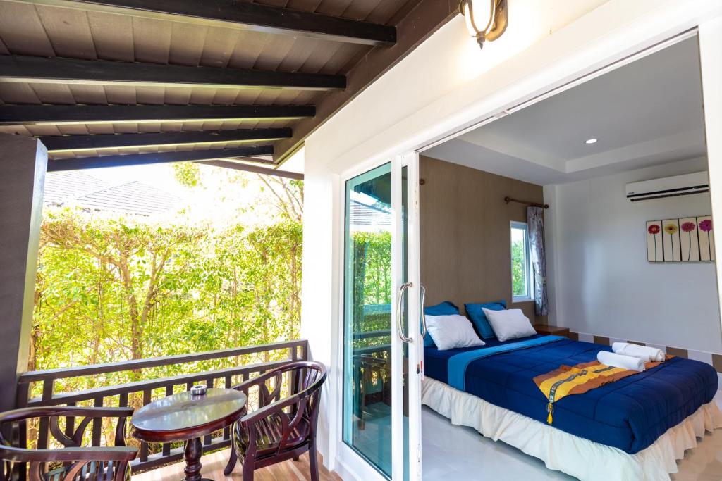 ein Schlafzimmer mit einem Balkon mit einem Bett und einem Tisch in der Unterkunft Nature Line Resort in Khanom