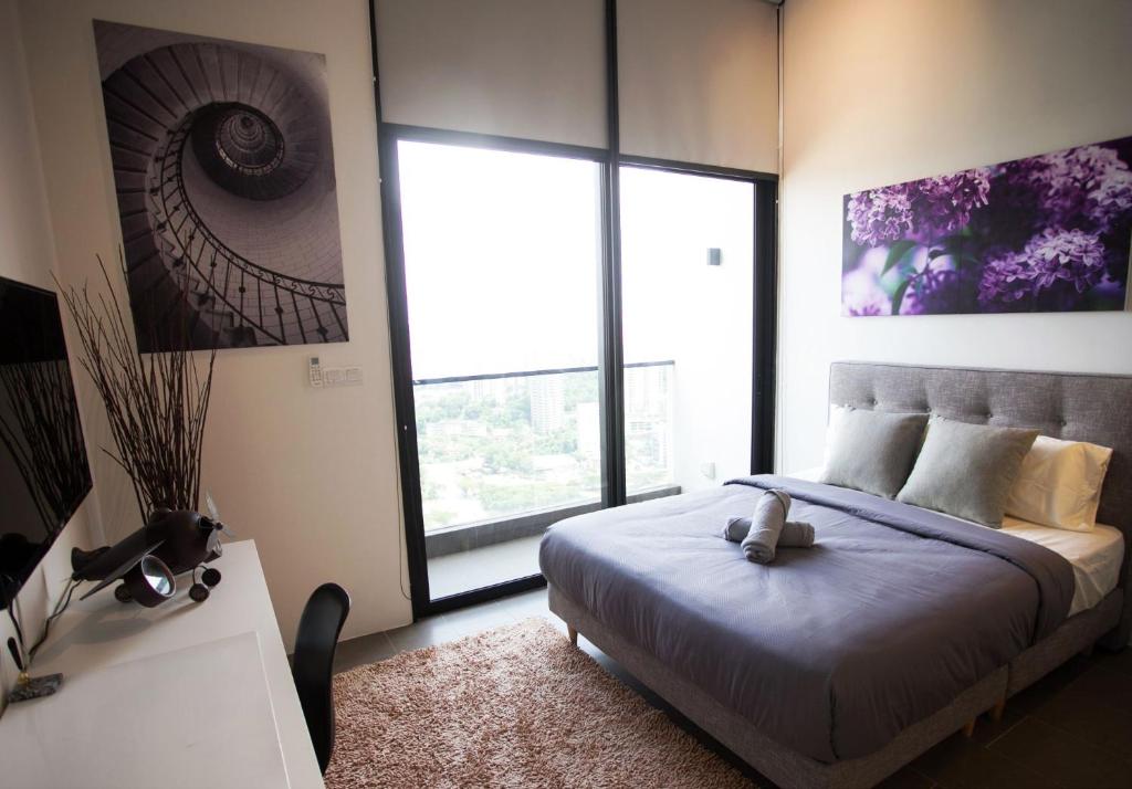 a bedroom with a bed and a large window at KL Sentral, EST Bangsar by SkyLimit Suites in Kuala Lumpur