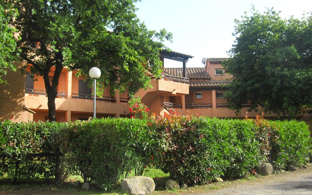 un edificio con un montón de arbustos y árboles en Studio apartment on the sea for couples or families, en Ghisonaccia