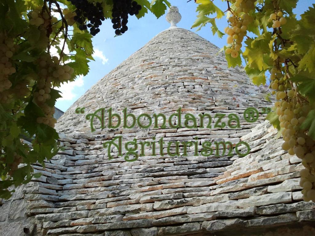 une tour en pierre avec un panneau en haut dans l'établissement Room in BB - Abbondanza The Farm House, à Alberobello