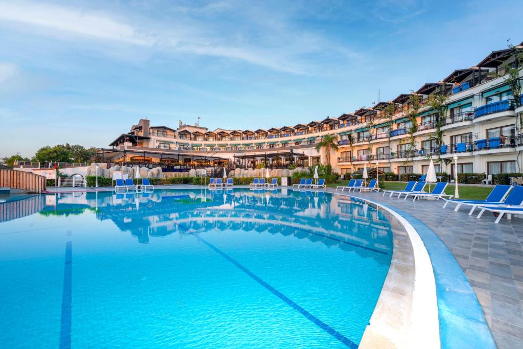 uma piscina em frente a um grande edifício em Armas Labada em Kemer