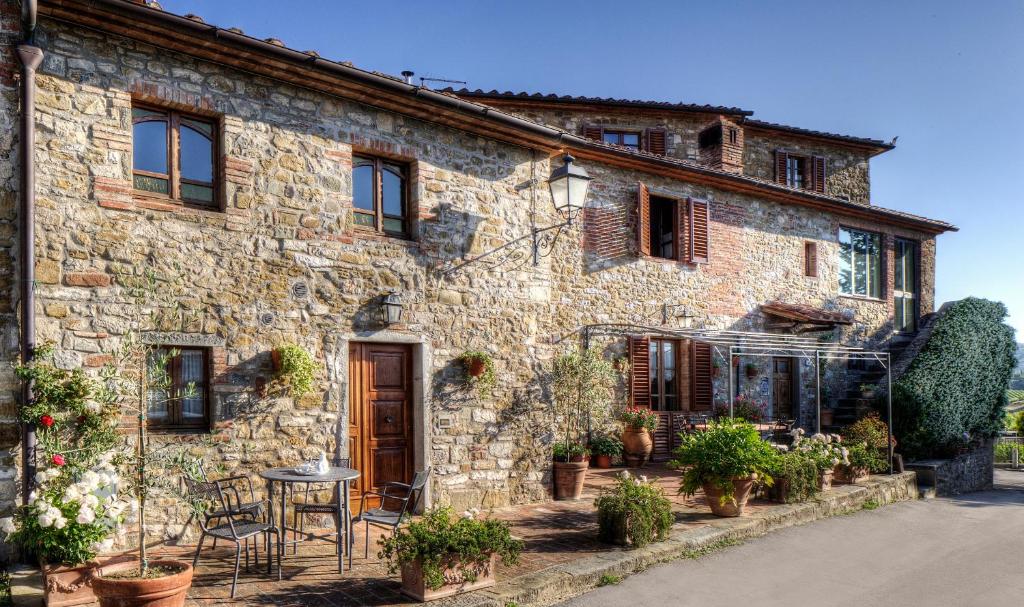 una vieja casa de piedra con una mesa delante en B&B Antiche Rime, en Gaiole in Chianti