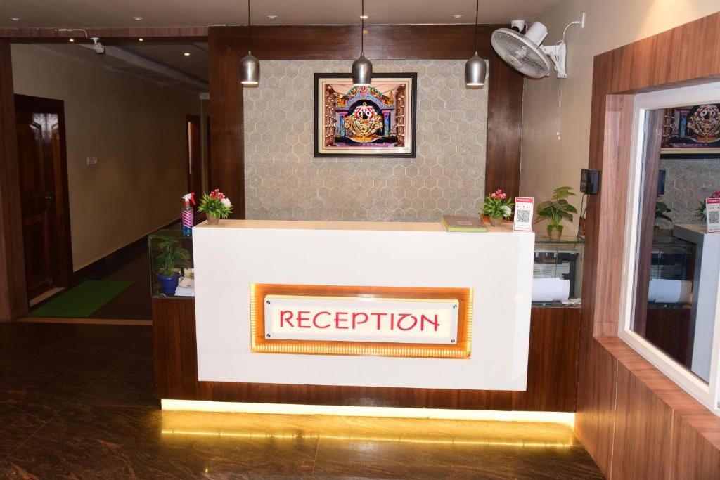 een receptie in de lobby van het hotel met een bordje bij Hotel Guru Estate in Puri