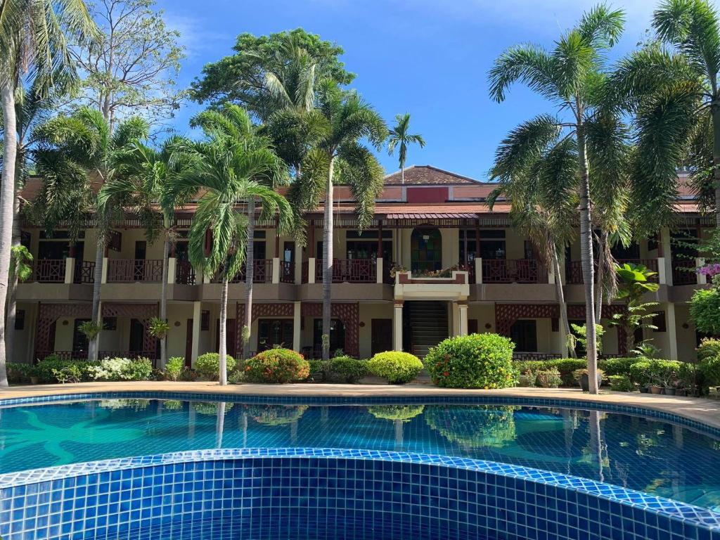 a swimming pool in front of a building with palm trees at Rattana Guesthouse & Bungalow in Chaweng