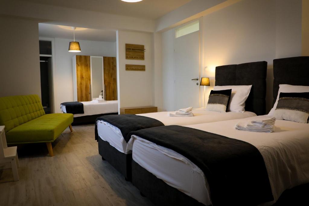 una habitación de hotel con 2 camas y una silla verde en SOBE - OPG Blašković, en Pleternica