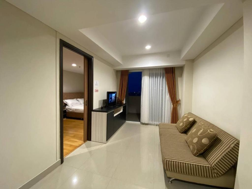 ein Wohnzimmer mit Sofa und ein Schlafzimmer in der Unterkunft MG Suites 1 Bedroom Apartment Sea View Semarang (KUMU SUITES) in Semarang