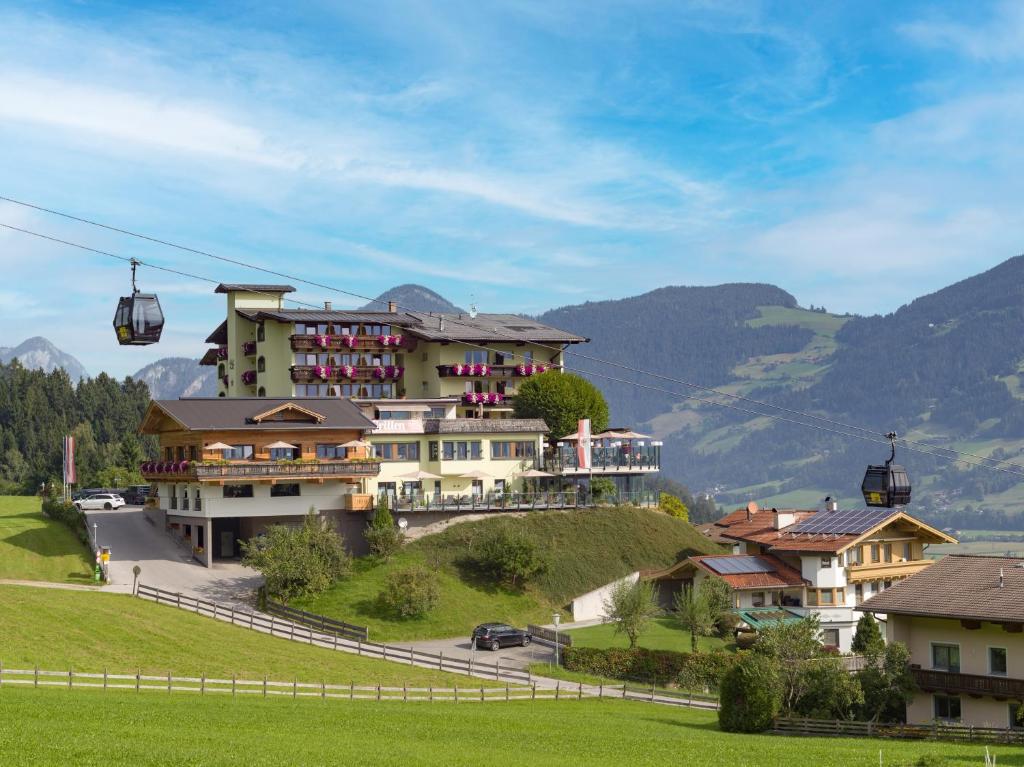 Hotel Waldfriede - Der Logenplatz im Zillertal في فوغين: منزل على تلة مع مصعد التزلج