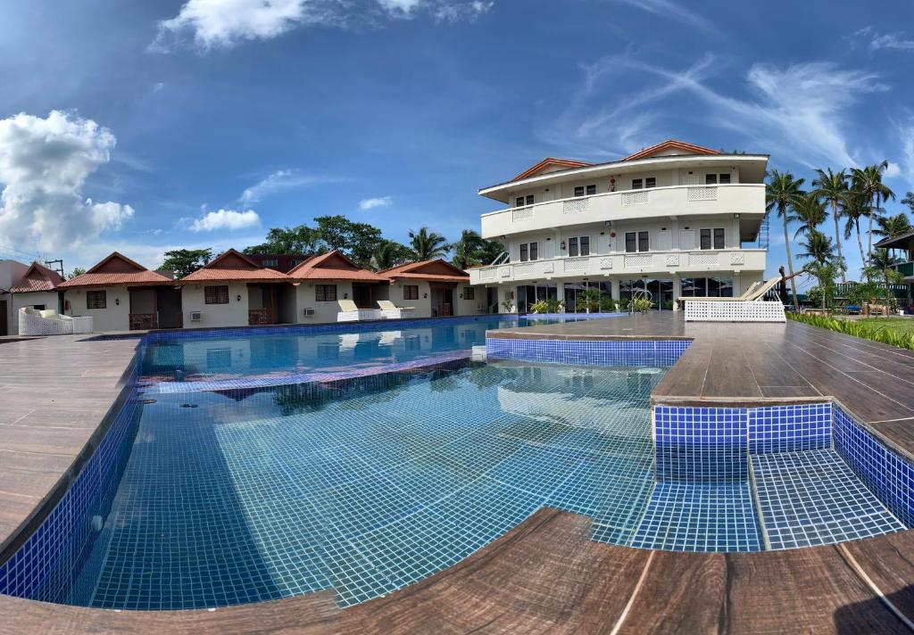 a large swimming pool in front of a building at Shoreland Beach Resort by Cocotel in Nasugbu