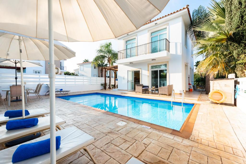 eine Villa mit einem Pool und einem Sonnenschirm in der Unterkunft Villa Palm Breeze by Ezoria Villas in Protaras