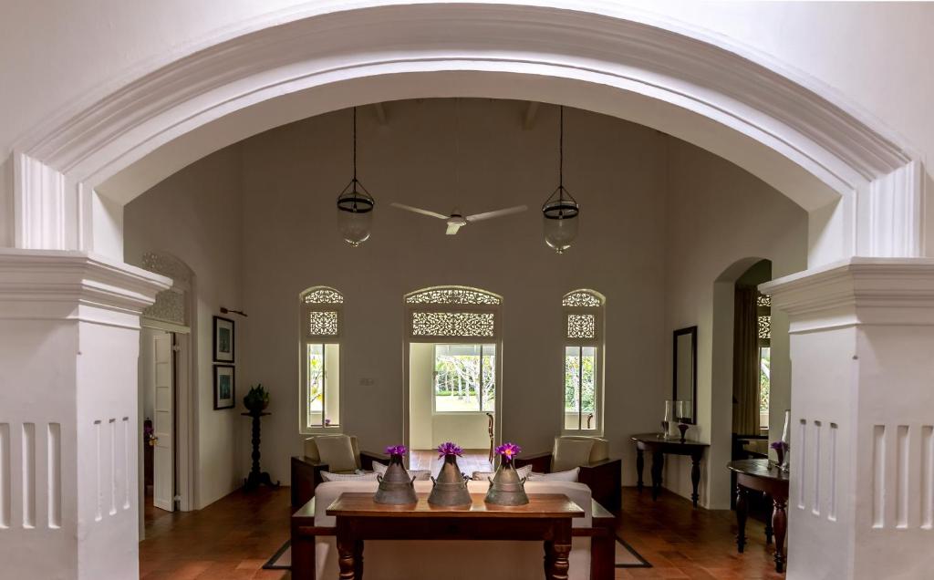 an archway in a room with a table and chairs at Nyne Hotels Rock Villa, Bentota in Bentota