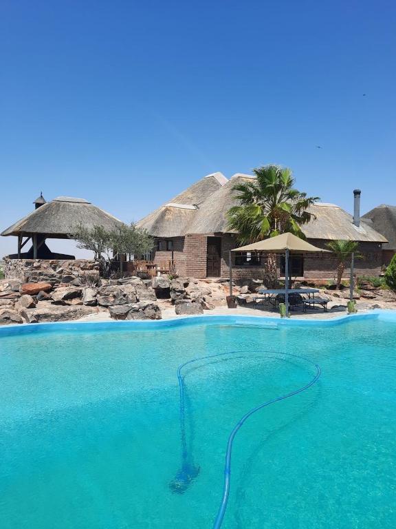 a swimming pool with blue water in front of a resort at Slypsteen Accomodation in Sternham