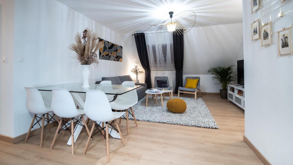 een eetkamer en een woonkamer met een tafel en stoelen bij Superbe appartement au coeur du Colmar in Colmar